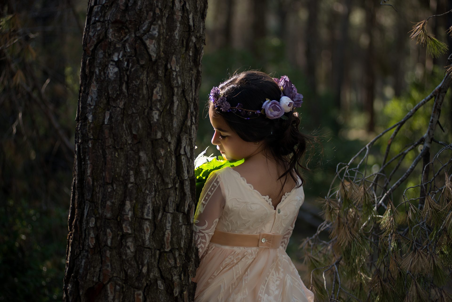 ruthestudio fotografia comunion niña en el bosque apoyada en un árbol
