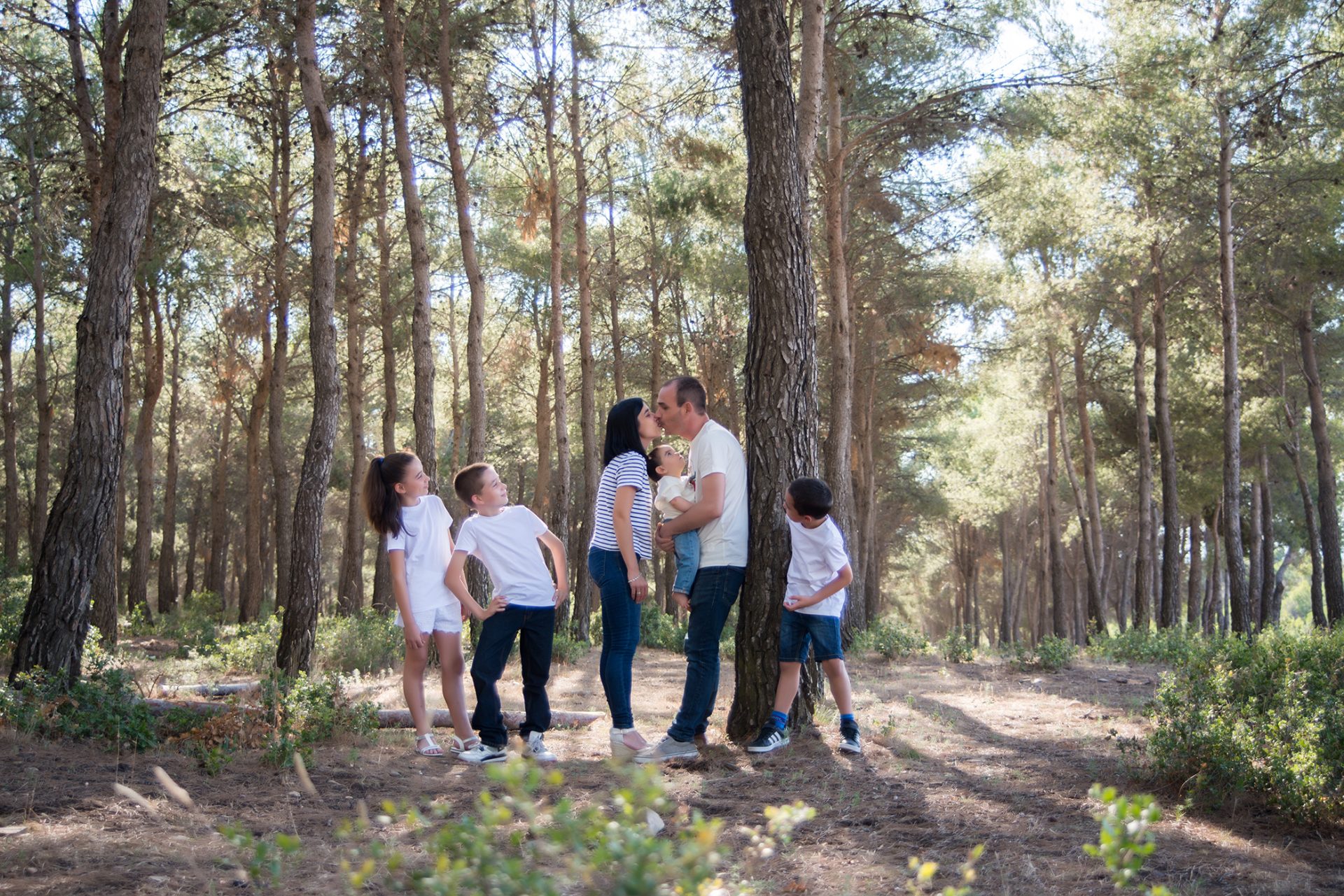 Fotografía de familia en el bosque de un matrimonio con sus cuatros hijos